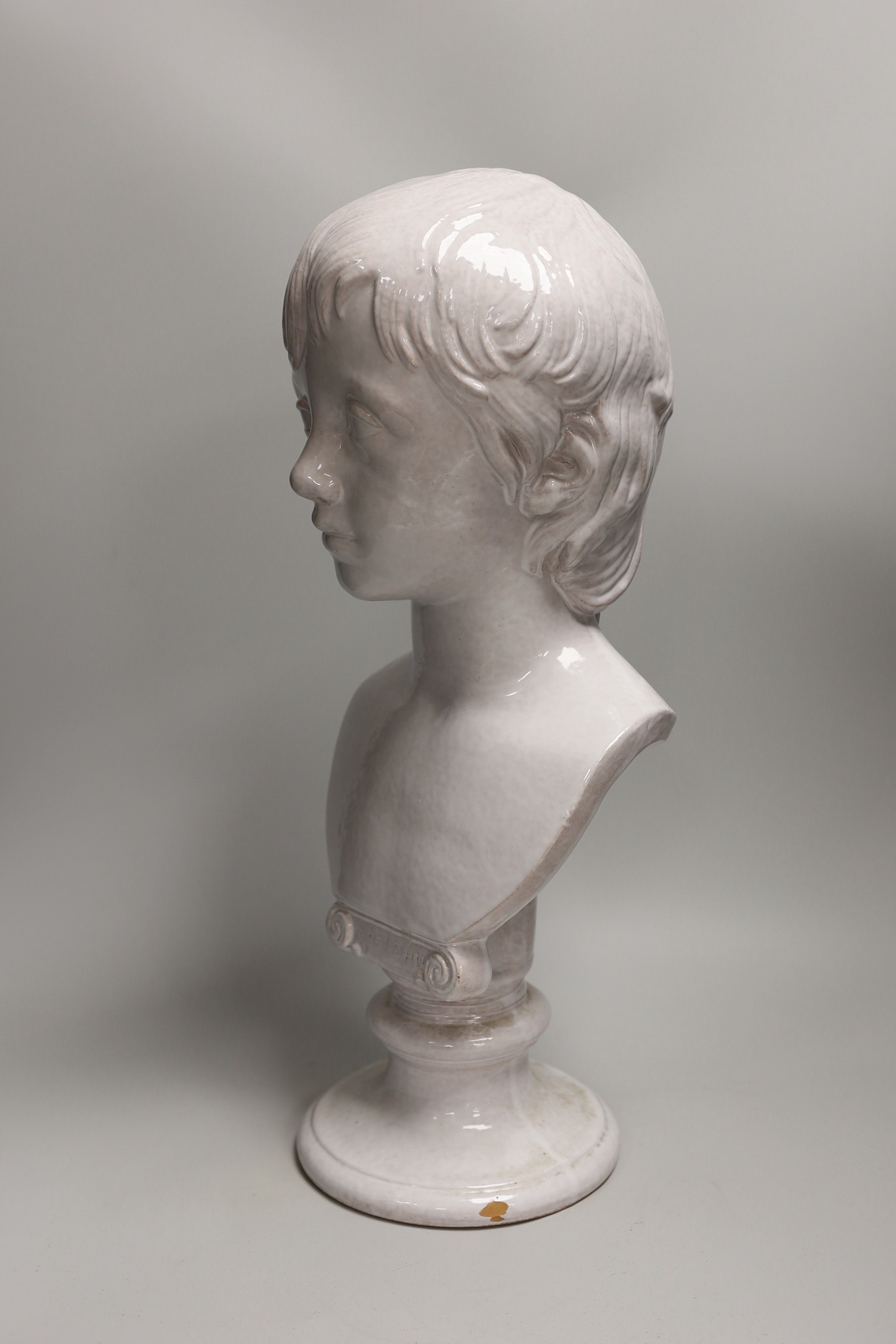 A Continental tin glazed terracotta bust of a boy, 47cm tall